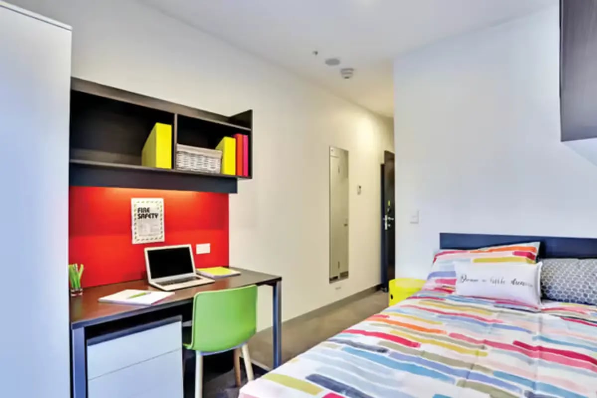Desk with laptop and bed Bedroom at Scape Melbourne Central in Melbourne Student Accommodation