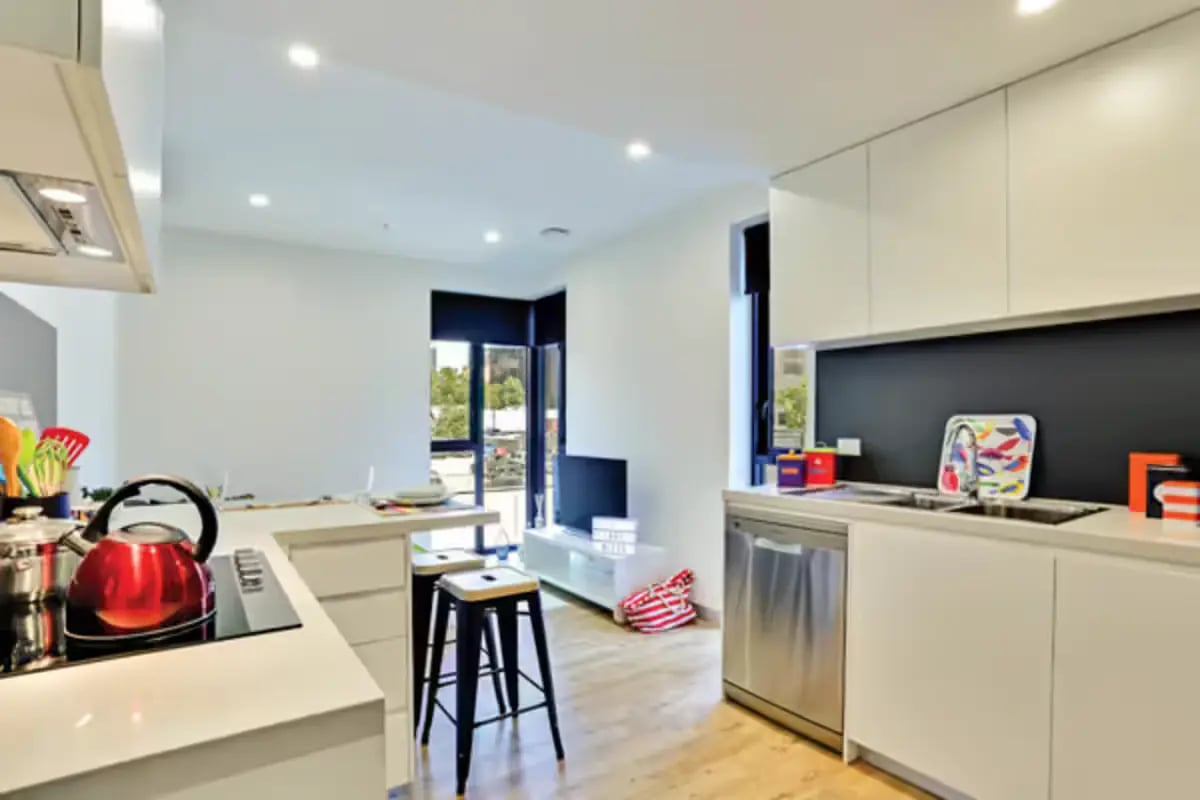 Modern kitchen with red kettle dishwasher sink kitchen at Scape Melbourne Central in Melbourne Student Accommodation
