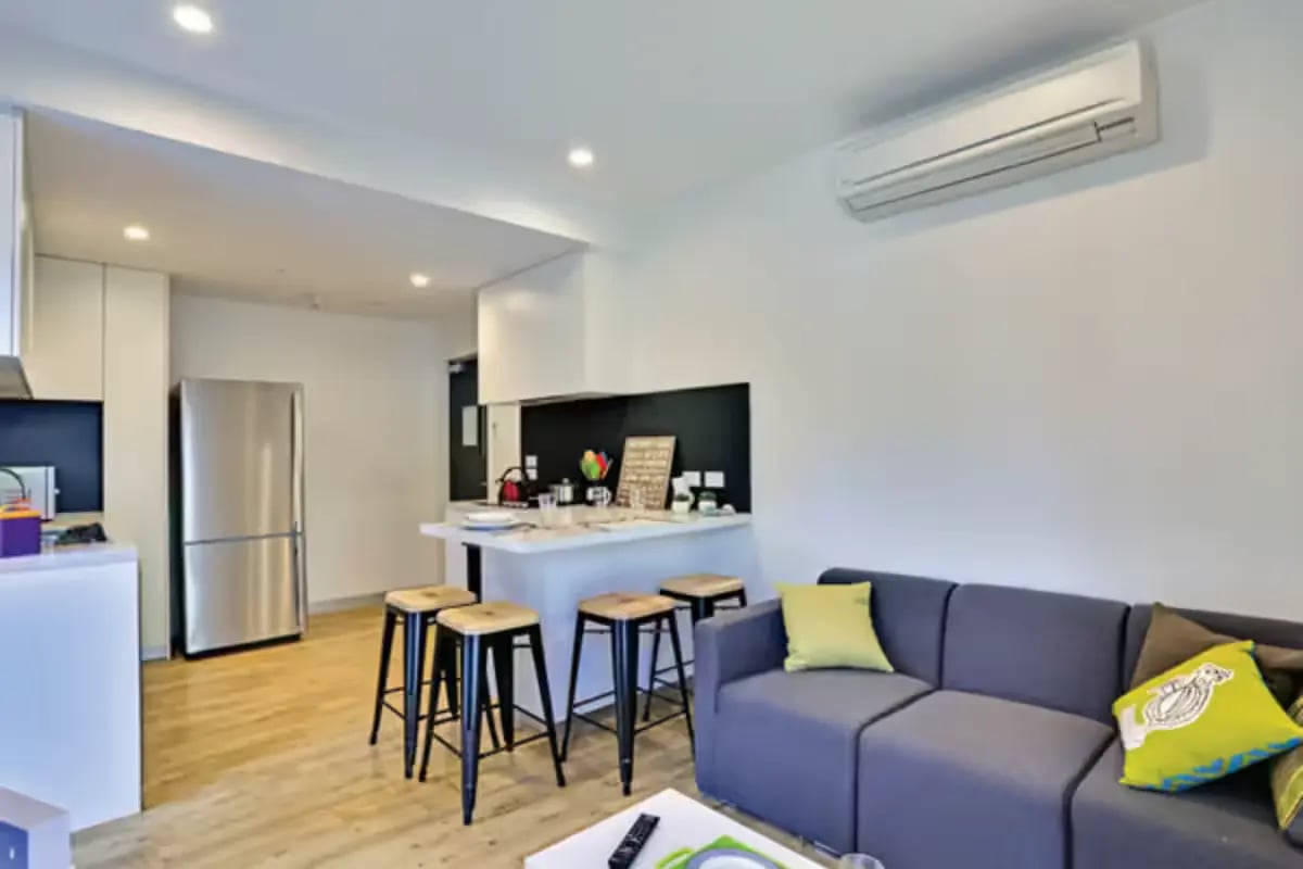 Sofa refrigerator kitchen island stools living room at Scape Melbourne Central in Melbourne Student Accommodation