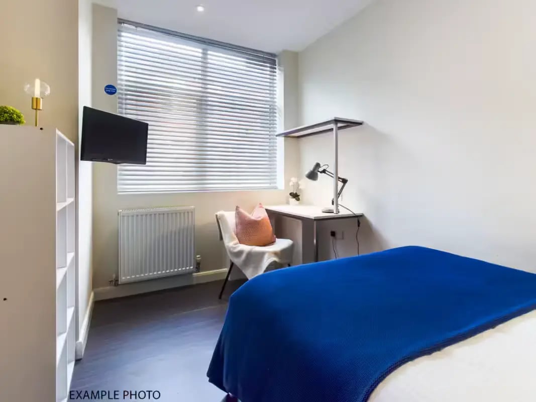 Bed with blue throw desk chair lamp bedroom at 125 Leek Road in Stoke-On-Trent Student Accommodation