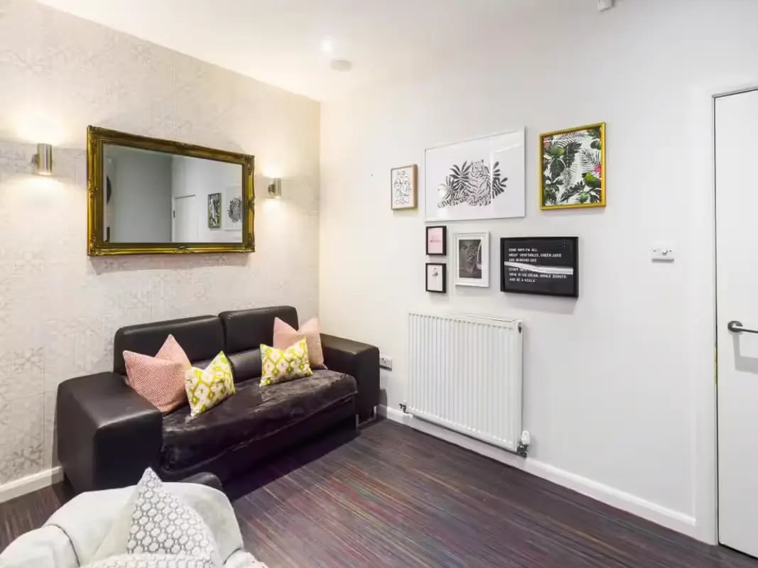 Leather couch patterned pillows framed art radiator living room at 125 Leek Road in Stoke-On-Trent Student Accommodation
