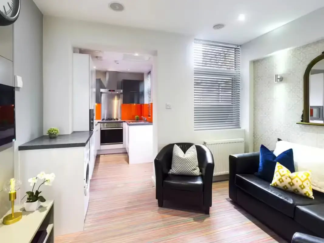 Kitchen with orange backsplash and black sofa living room at 6 Guildford Street in Stoke-On-Trent Student Accommodation
