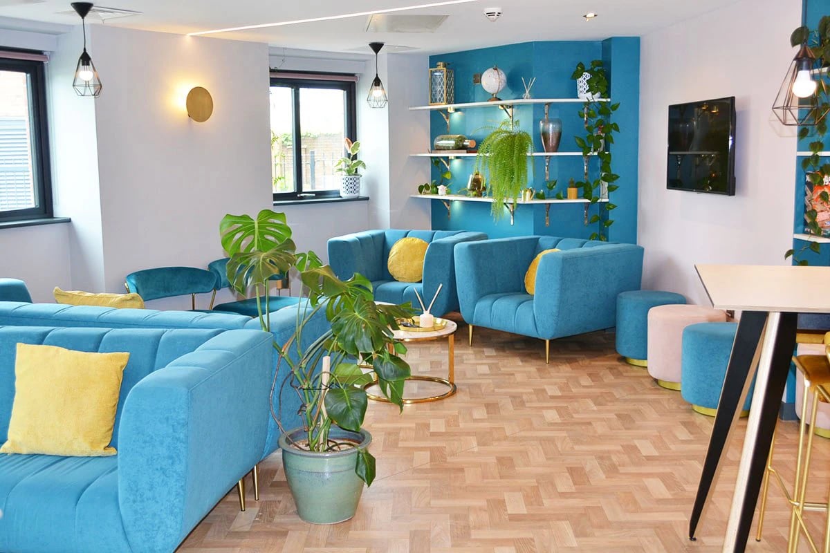 Turquoise sofas with yellow cushions living room at Red Queen - Coventry in Coventry Student Accommodation