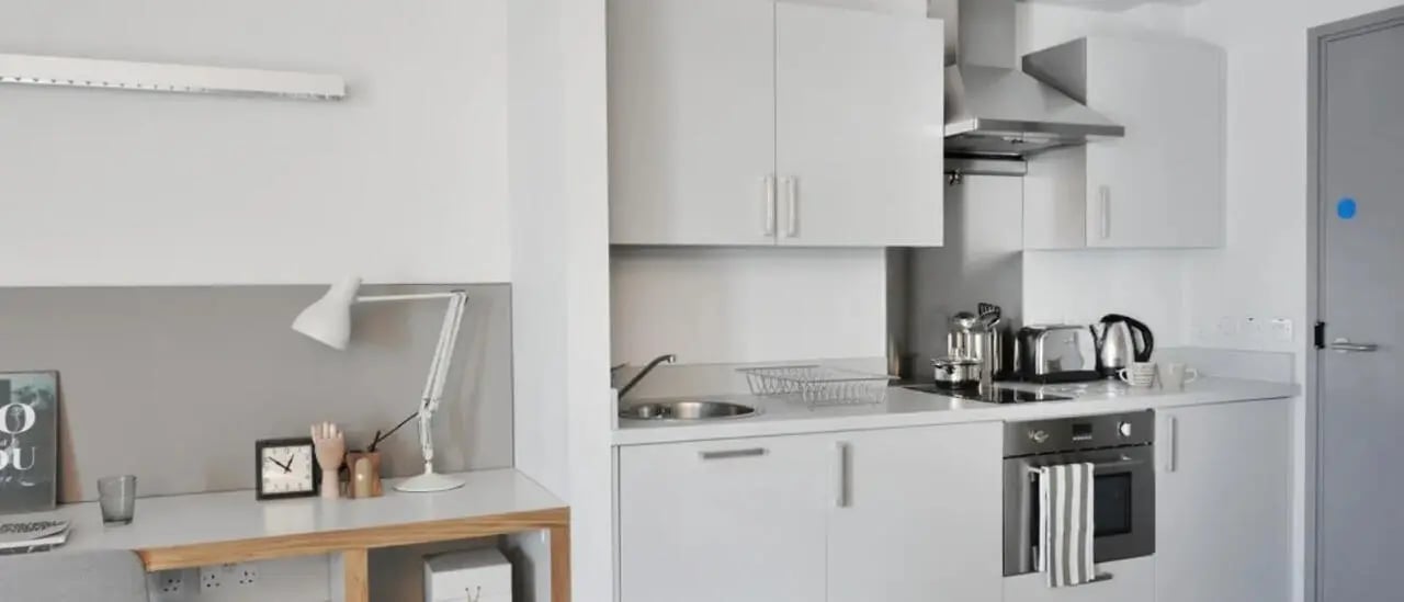 Desk lamp clock toaster kettle and oven kitchen at Victoria Hall Kings Cross in London Student Accommodation