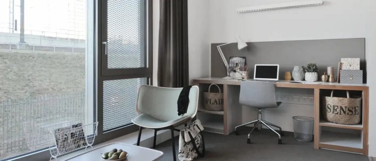 Desk laptop chair lamp baskets study area at Victoria Hall Kings Cross in London Student Accommodation