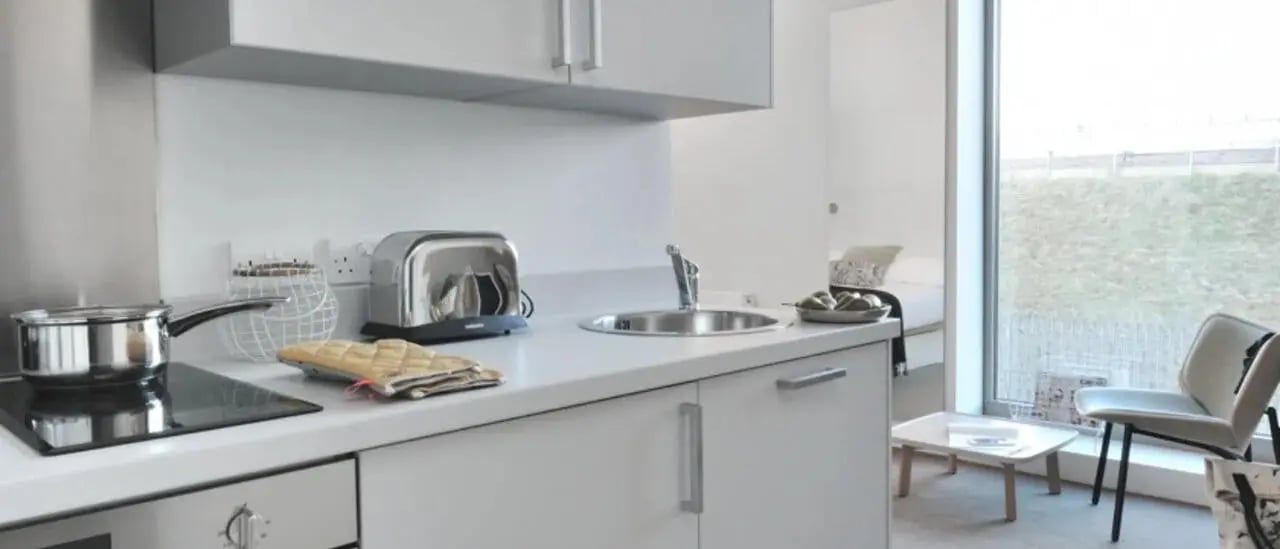 Kitchen area with pot toaster sink bed visible Kitchen at Victoria Hall Kings Cross in London Student Accommodation