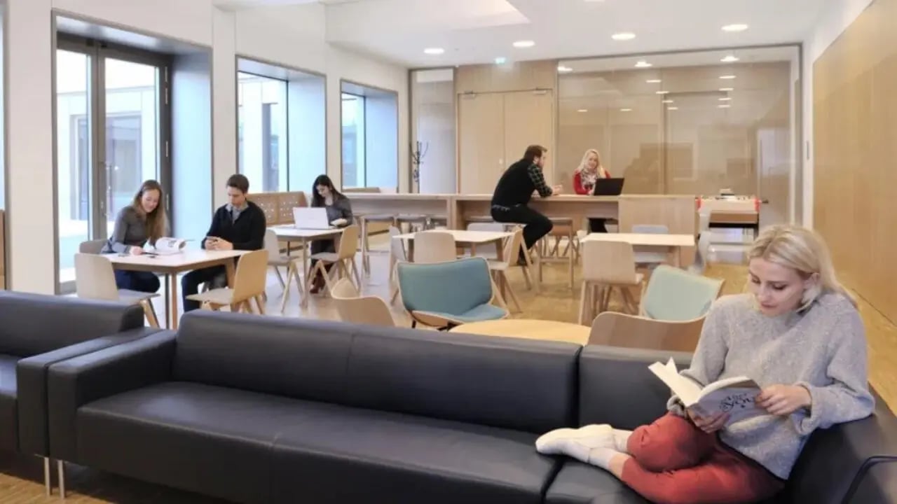 Students studying and relaxing in common area living room at Victoria Hall Kings Cross in London Student Accommodation