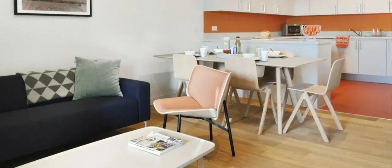 Sofa dining table chairs kitchen cabinets living room at Victoria Hall Kings Cross in London Student Accommodation