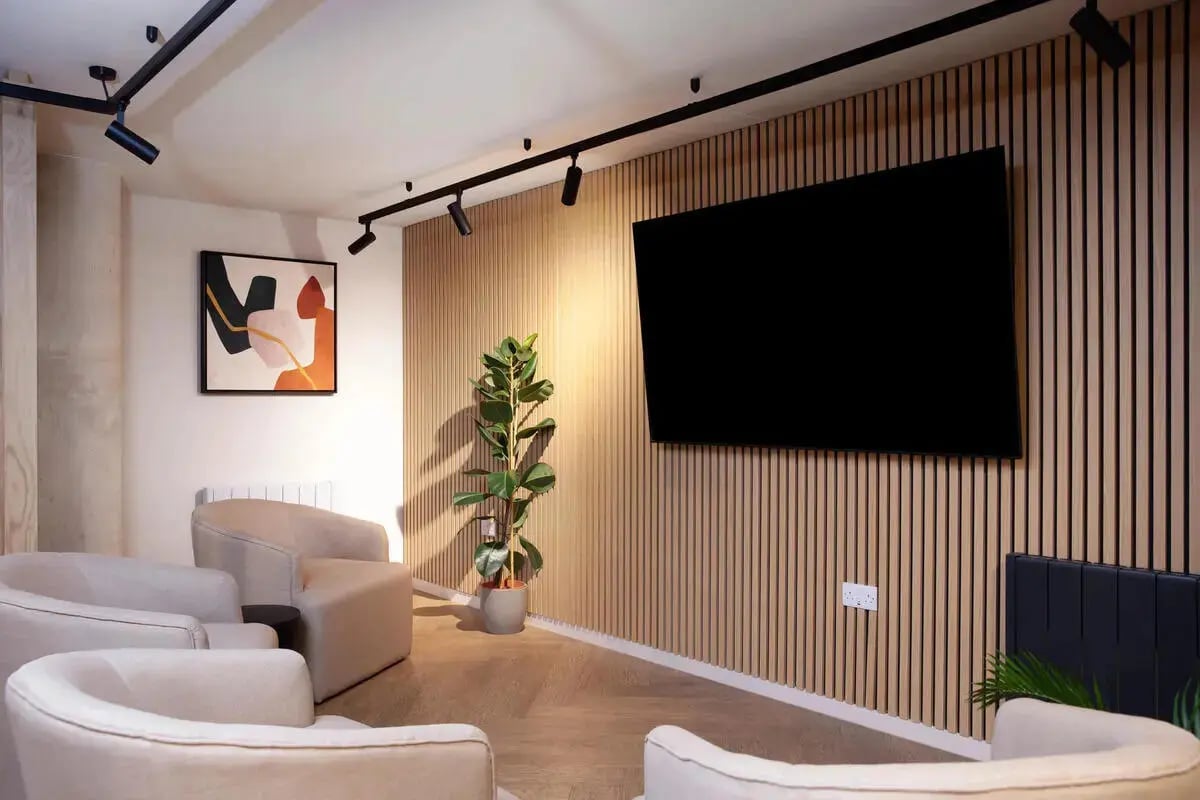 Comfortable armchairs and art above radiator living room at Stapleton House in London Student Accommodation