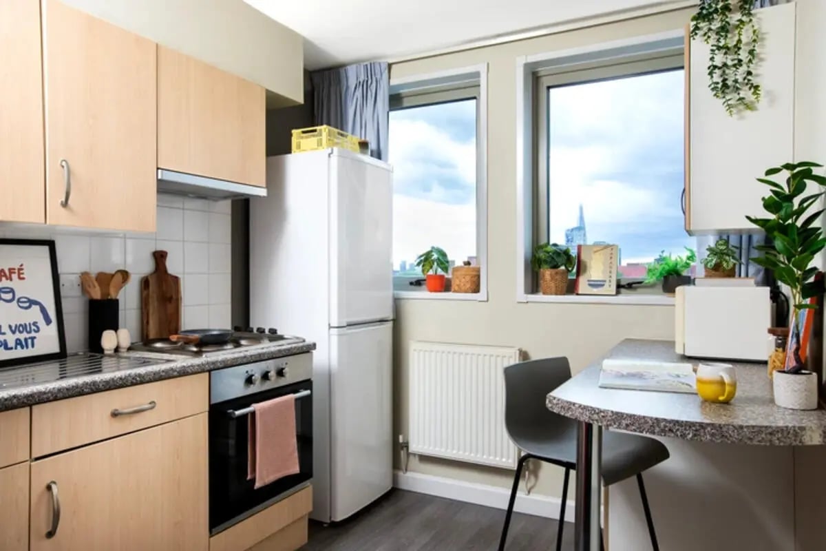 Kitchen with fridge oven microwave and seating kitchen at Quantum Court in London Student Accommodation