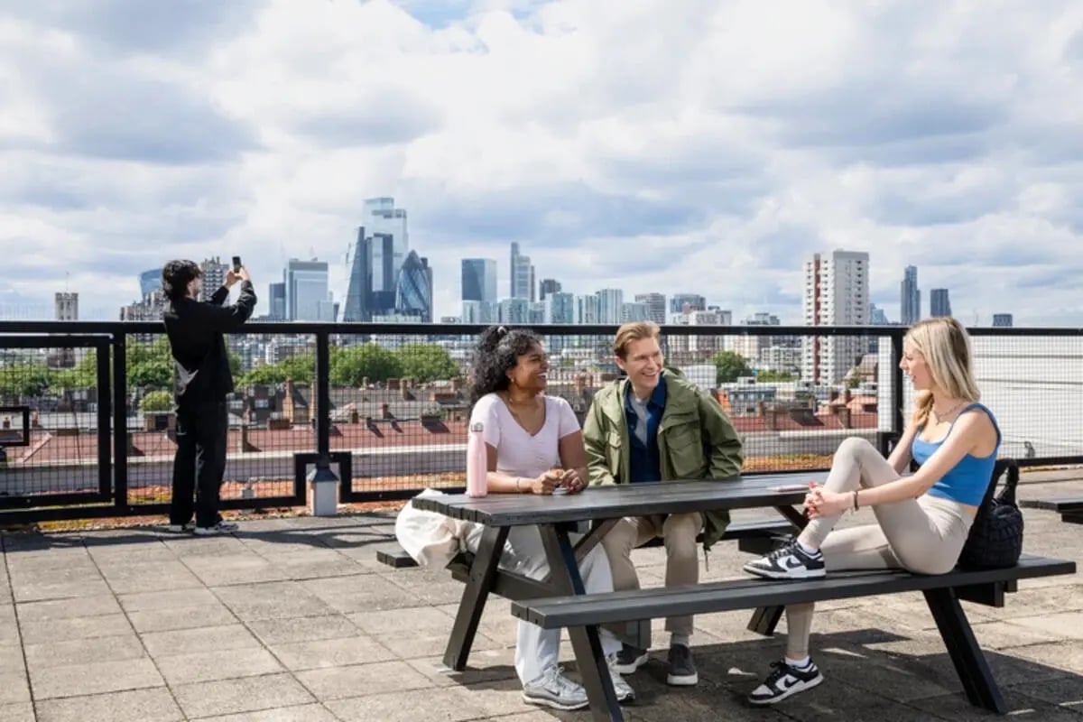 Students on picnic table outdoor lounge area at Quantum Court in London Student Accommodation