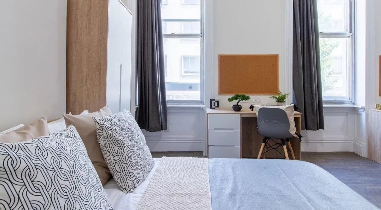 Bed desk chair curtains and window bedroom at Bloomsbury Janet Poole House in London Student Accommodation