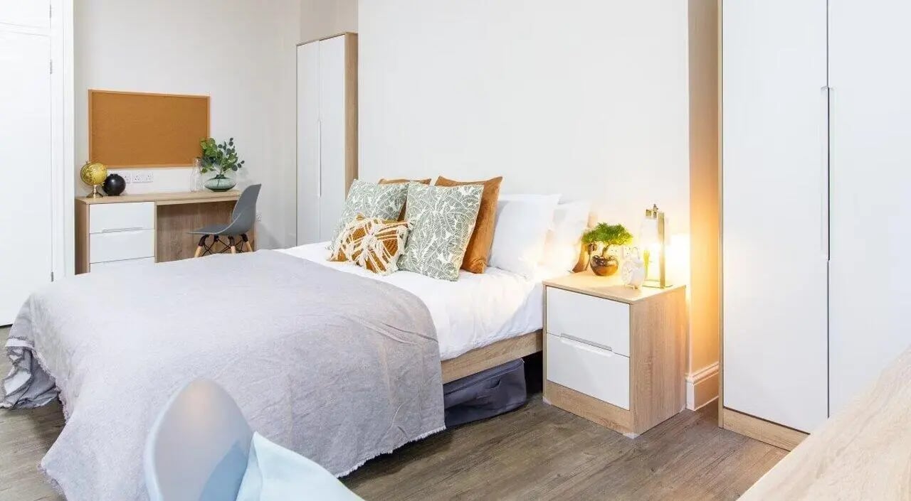 Bed desk wardrobe and bedside table bedroom at Bloomsbury Janet Poole House in London Student Accommodation