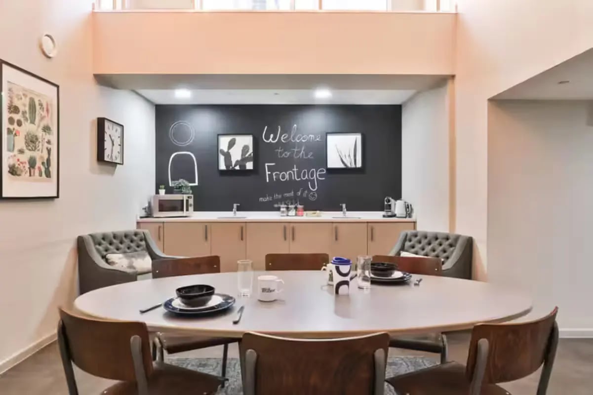 Chalkboard wall microwave chairs table kitchen area at The Frontage in Nottingham Student Accommodation