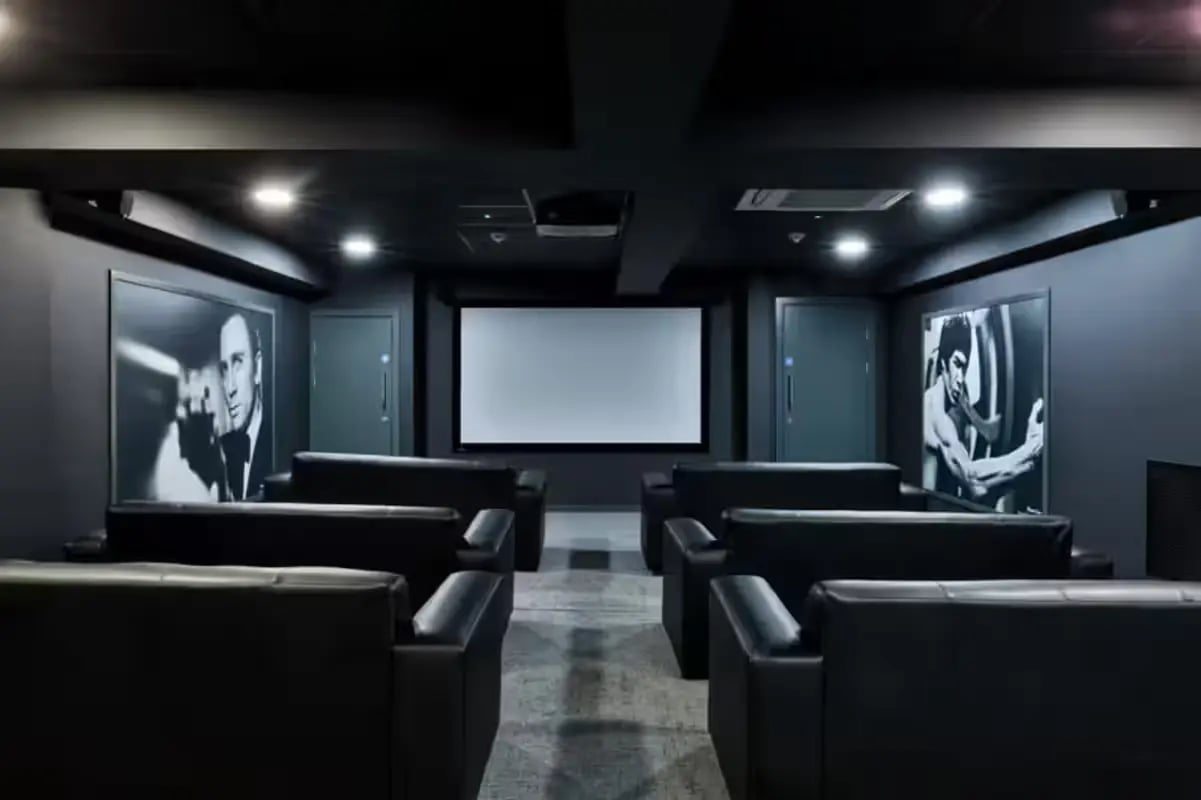 Black leather couches facing large screen and movie posters cinema at The Frontage in Nottingham Student Accommodation