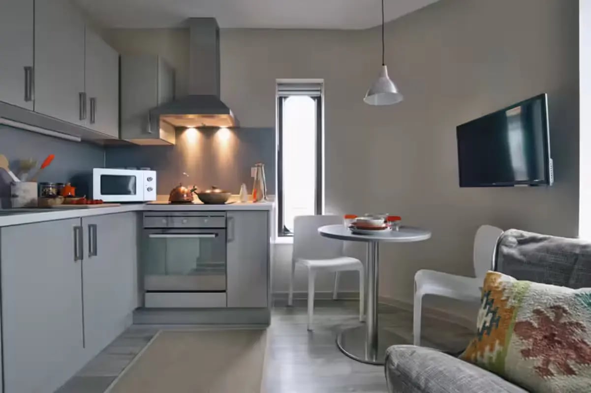 Modern kitchen with table chairs and TV living area at The Frontage in Nottingham Student Accommodation