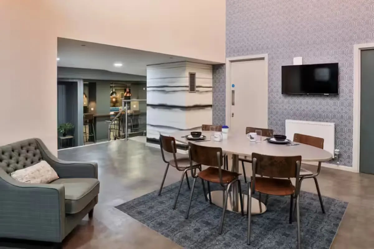 Chairs around oval table with sofa living area at The Frontage in Nottingham Student Accommodation