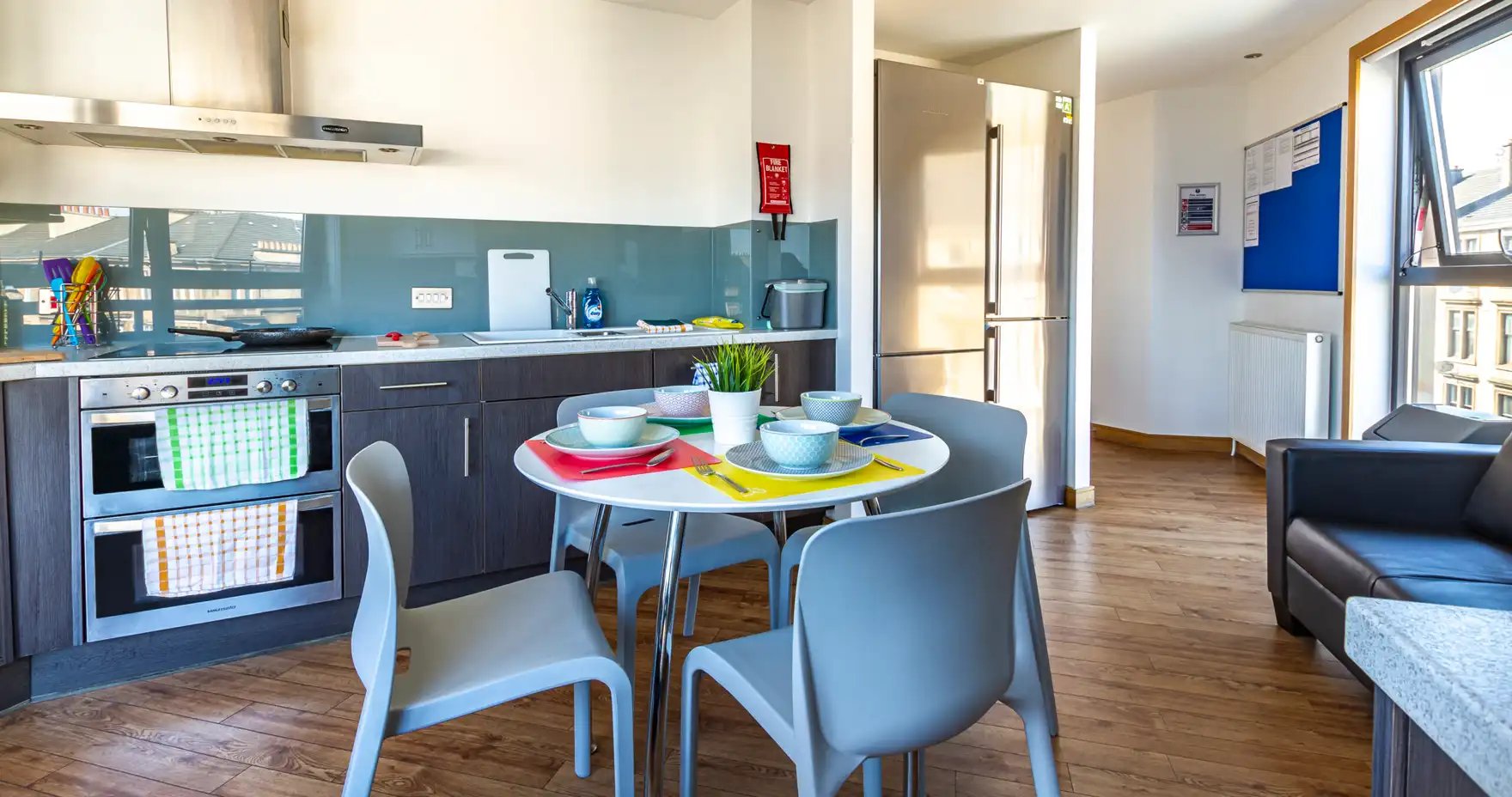 Kitchen with table chairs and sofa. at Kaplan Living Glasgow - Argyle Street in Glasgow Student Accommodation