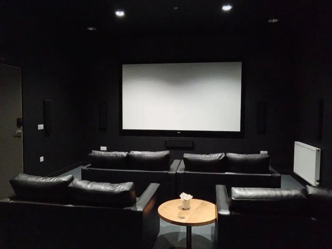 Black couches white screen speakers and table cinema at Bath Street in Glasgow Student Accommodation