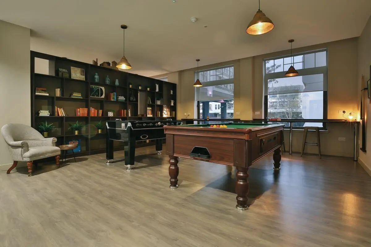 Pool and foosball tables armchair bookshelves leisure room at Bath Street in Glasgow Student Accommodation