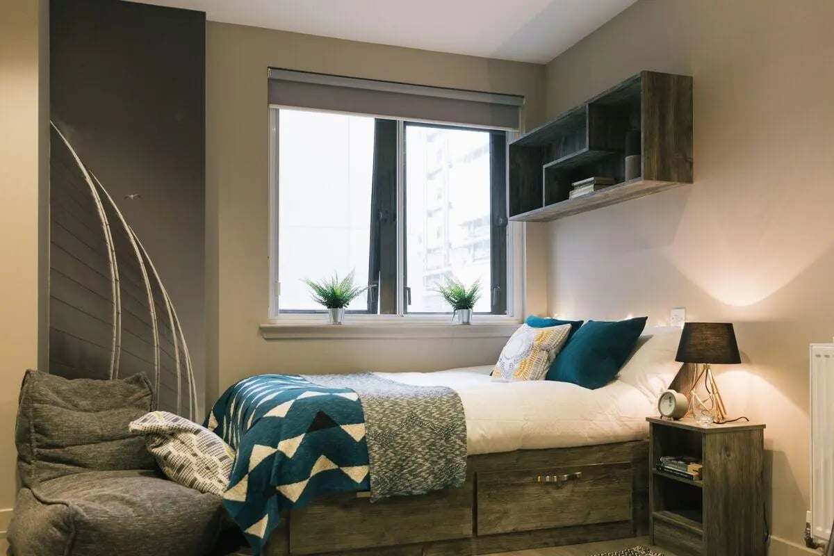 Bed with blue blanket shelf nightstand Bedroom at Bath Street in Glasgow Student Accommodation