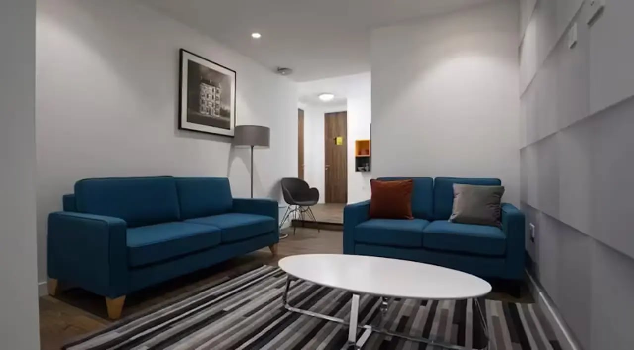 Two blue sofas white oval coffee table living room at Riverside Glasgow in Glasgow Student Accommodation