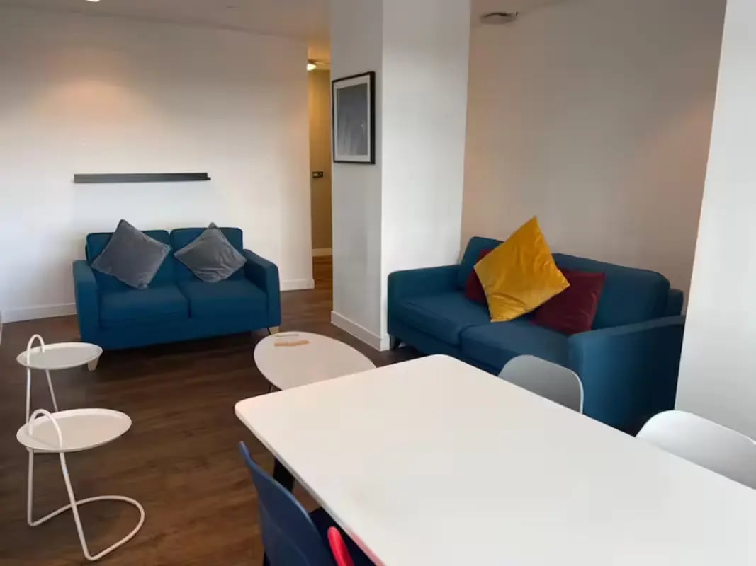 Two blue sofas with pillows and tables living room at Riverside Glasgow in Glasgow Student Accommodation
