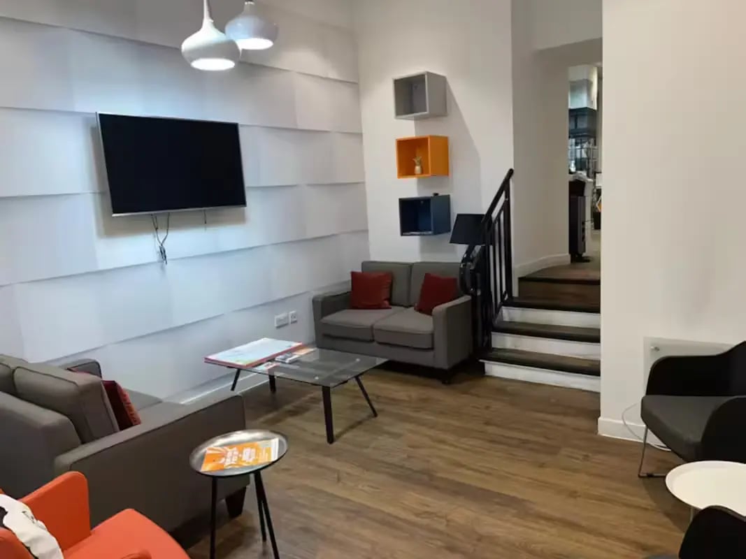 Sofas television tables and stairs living room at Riverside Glasgow in Glasgow Student Accommodation