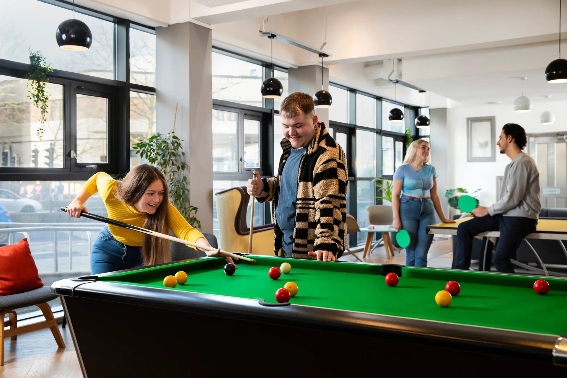 Students playing pool and table tennis recreation room at Phoenix Court in Bristol Student Accommodation