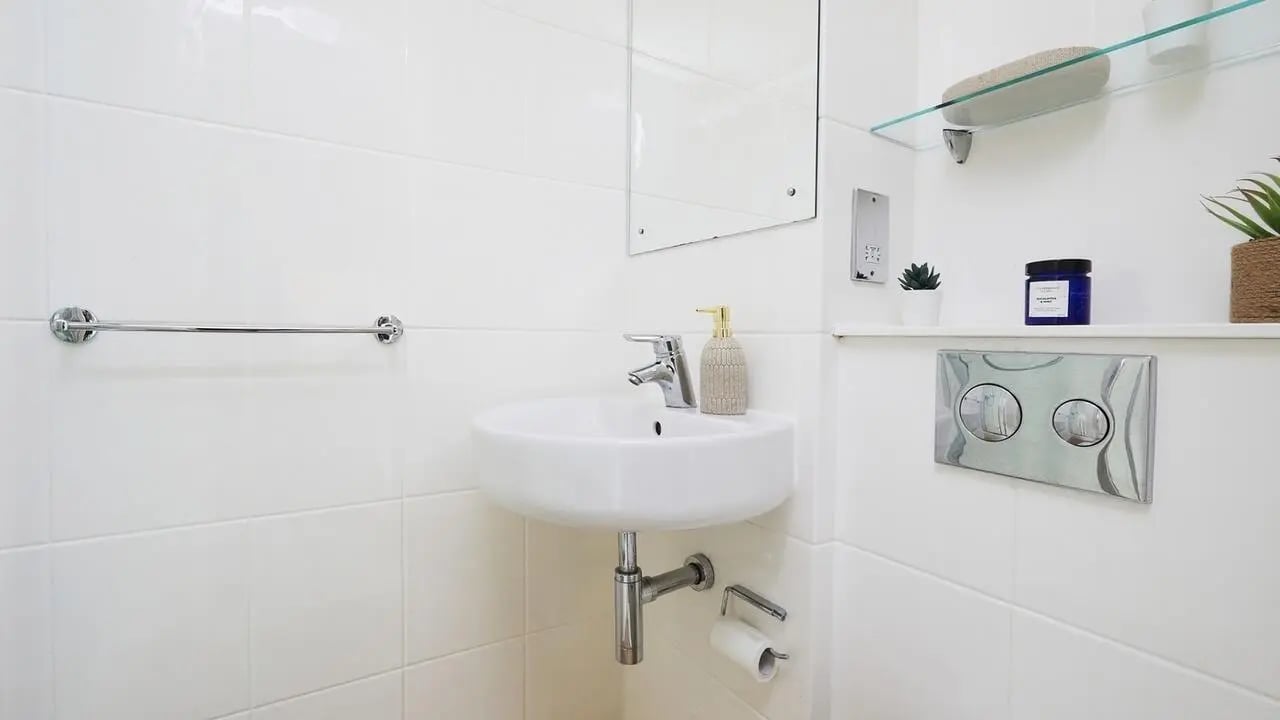 Sink soap dispenser toilet flush buttons bathroom at Collegiate Tower in Bristol Student Accommodation