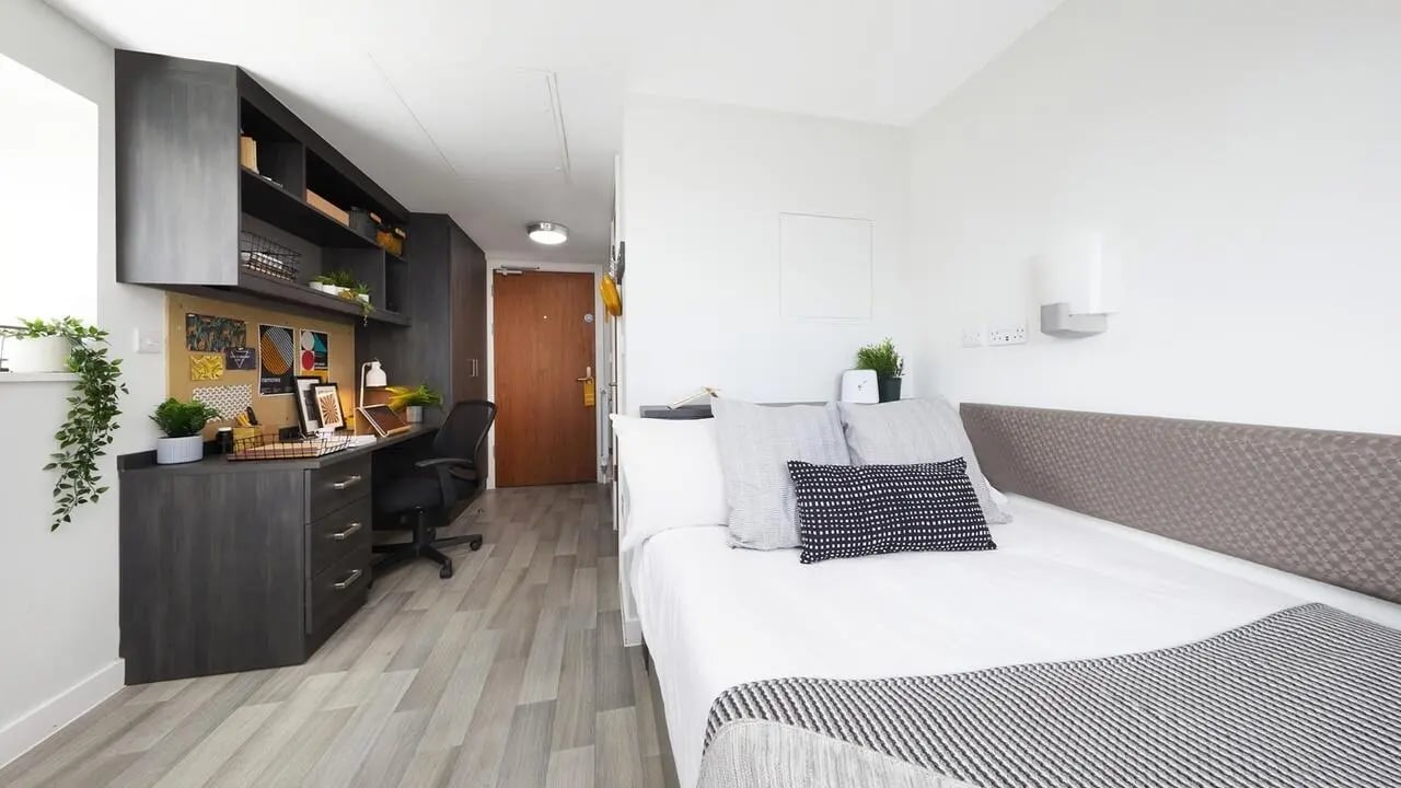 Desk and bed with pillows study area bedroom at Collegiate Tower in Bristol Student Accommodation