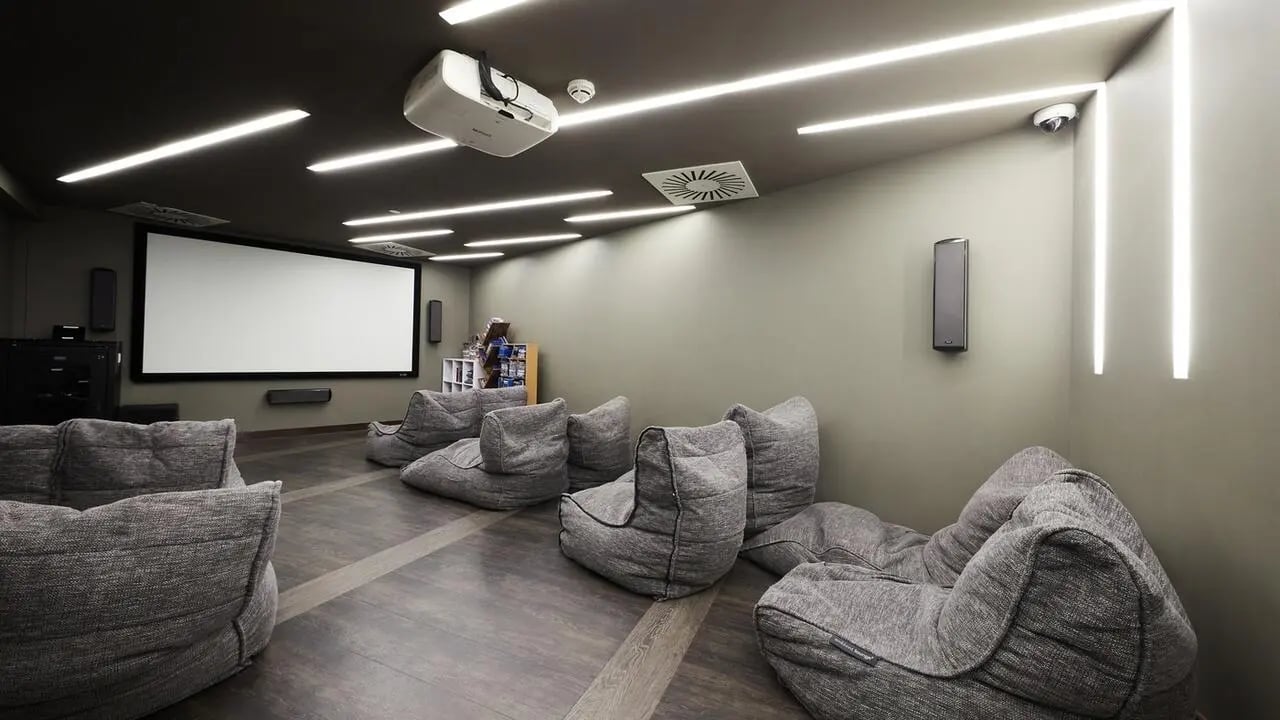 Beanbag chairs surround large screen projector and speakers cinema room at Collegiate Tower in Bristol Student Accommodation