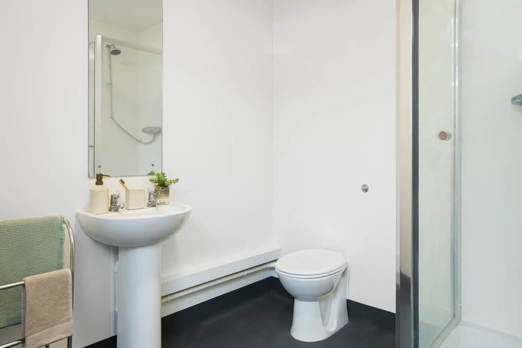 Sink toilet shower and towels bathroom at North Lodge in London Student Accommodation