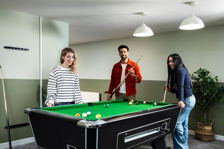 Students play pool on a green table living room at Pacific Court in London Student Accommodation