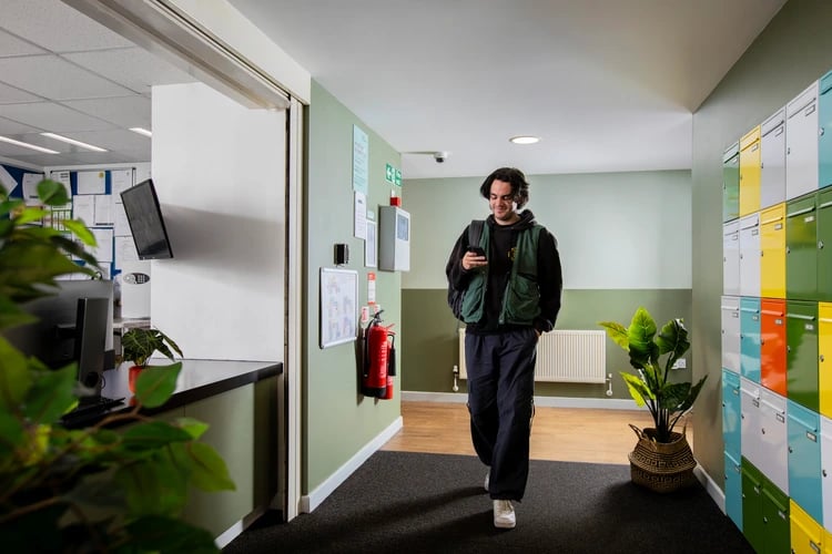 Student walks down hallway with mailboxes Interior shot at Pacific Court in London Student Accommodation