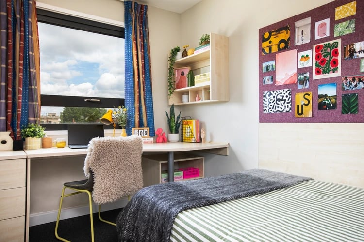 Desk with laptop chair and bed bedroom at Pacific Court in London Student Accommodation