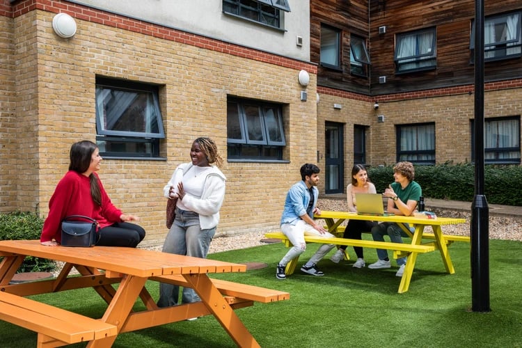 Students at picnic tables exterior at Pacific Court in London Student Accommodation