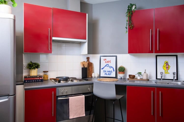 Red cabinets stove sink and bar stool kitchen at Somerset Court in London Student Accommodation