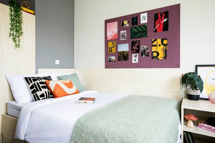 Bed with colorful pillows and bulletin board bedroom at Somerset Court in London Student Accommodation