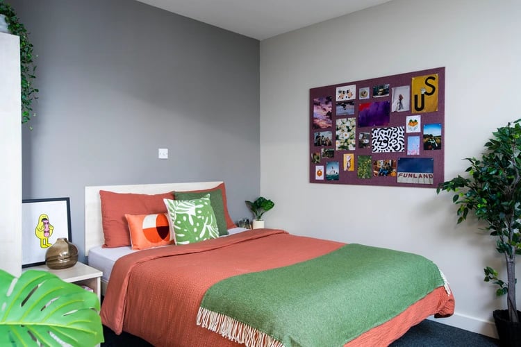 Bed with orange and green bedding pinned photos bedroom at Somerset Court in London Student Accommodation