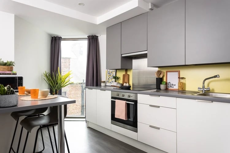 Modern kitchen with breakfast bar and grey cabinets kitchen at Newgate Court in Newcastle Upon Tyne Student Accommodation
