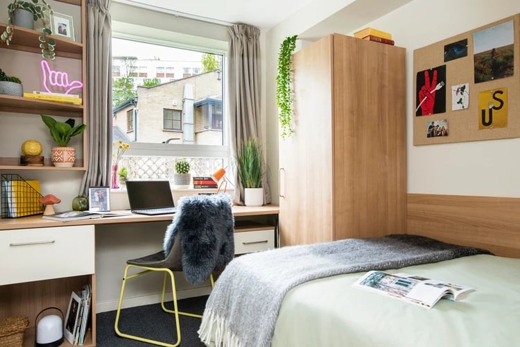 Bed desk shelving unit with laptop and wardrobe bedroom at Elizabeth Croll House in London Student Accommodation