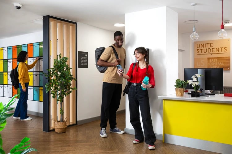 Students at colorful lockers and reception desk area at East Central House in London Student Accommodation