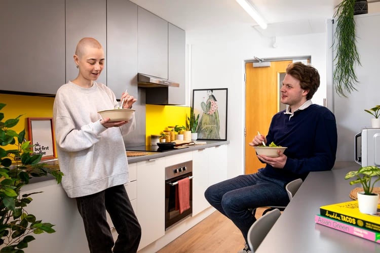 People eating salad at kitchen counter kitchen at East Central House in London Student Accommodation