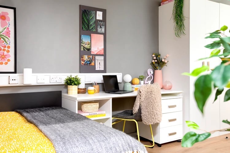 Desk with laptop plant and bed study area at East Central House in London Student Accommodation