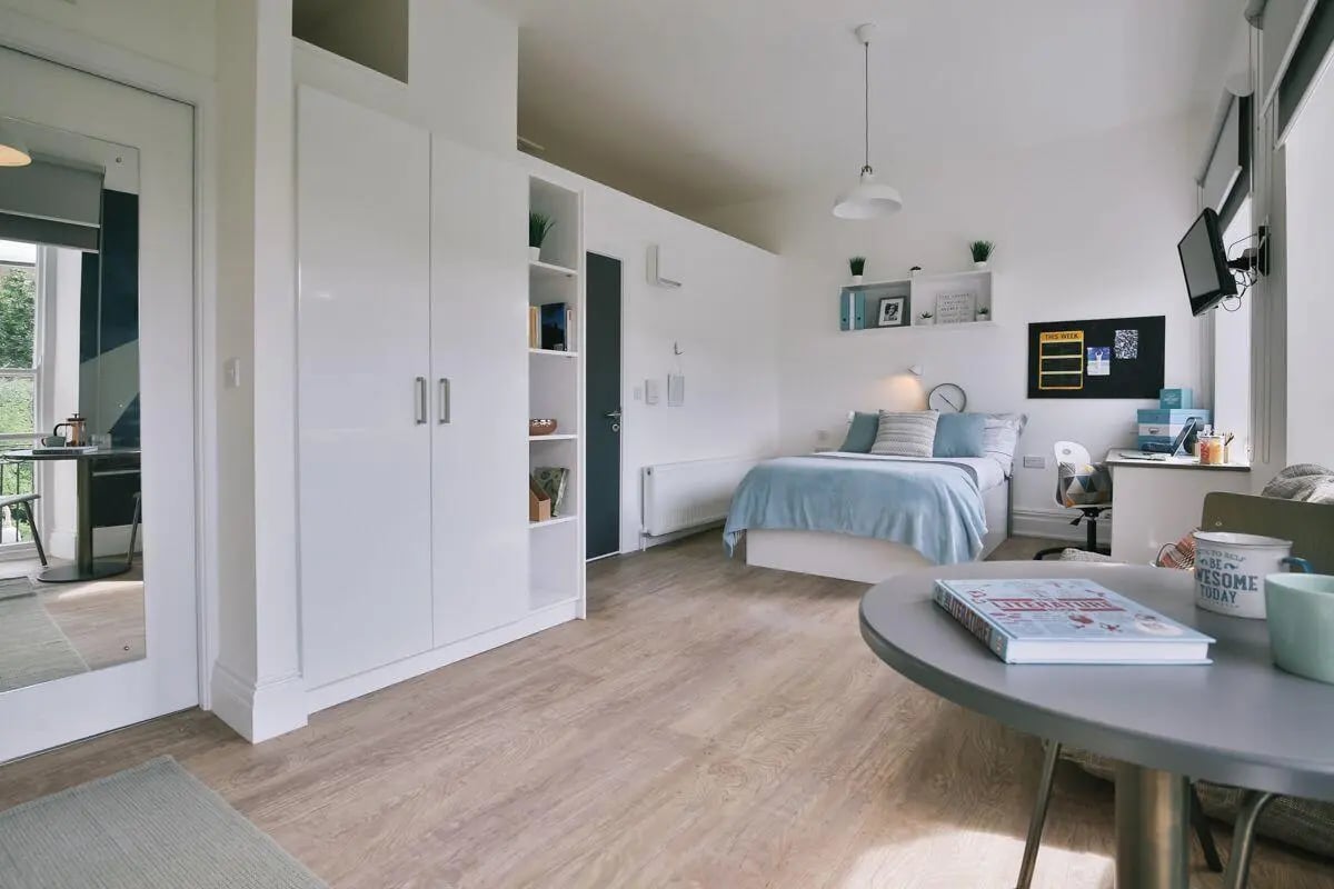 Studio apartment with bed desk wardrobe and table at Claremont Place in Newcastle Upon Tyne Student Accommodation