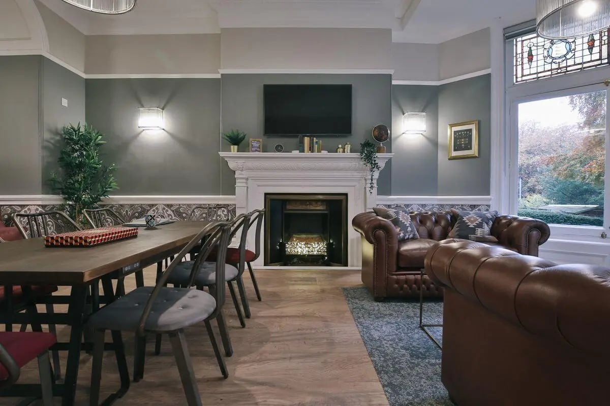 Dining table leather sofas fireplace living room at Claremont Place in Newcastle Upon Tyne Student Accommodation