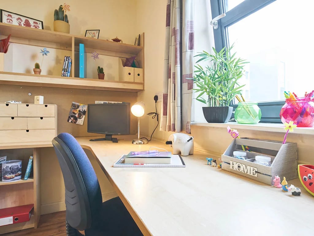 Desk with chair computer shelves and decorations study area at Europa in Liverpool Student Accommodation
