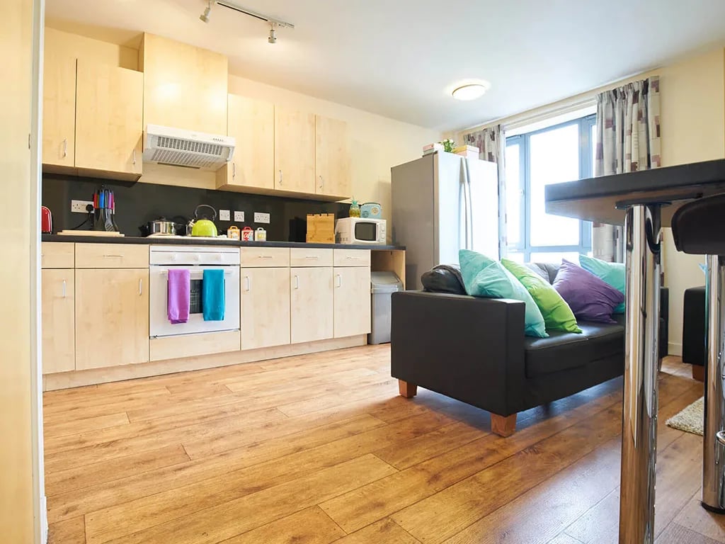 Kitchen with sofa and bar stools living area at Europa in Liverpool Student Accommodation