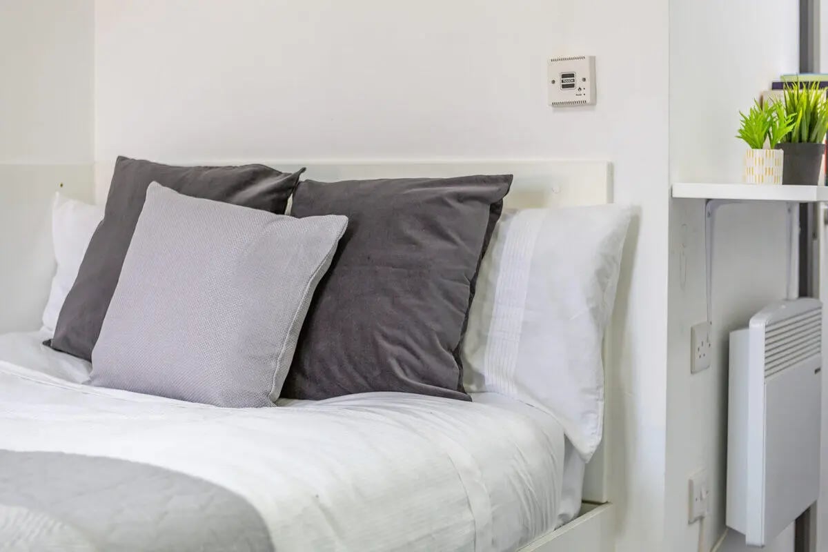 Bed with pillows and heater bedroom at Glassworks - Liverpool in Liverpool Student Accommodation